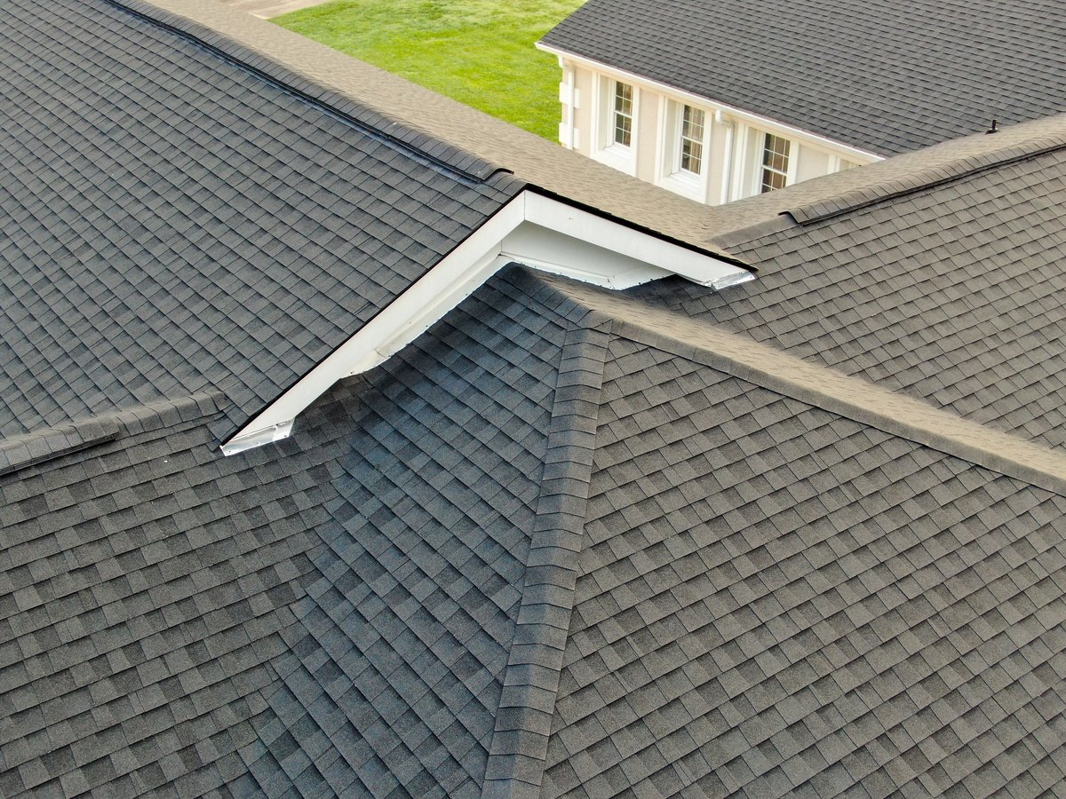 Asphalt shingle roof installation showing clean valleys, hip caps and ridge ventilation